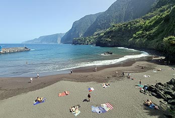 Sunny day at the black sand beach of Seixal